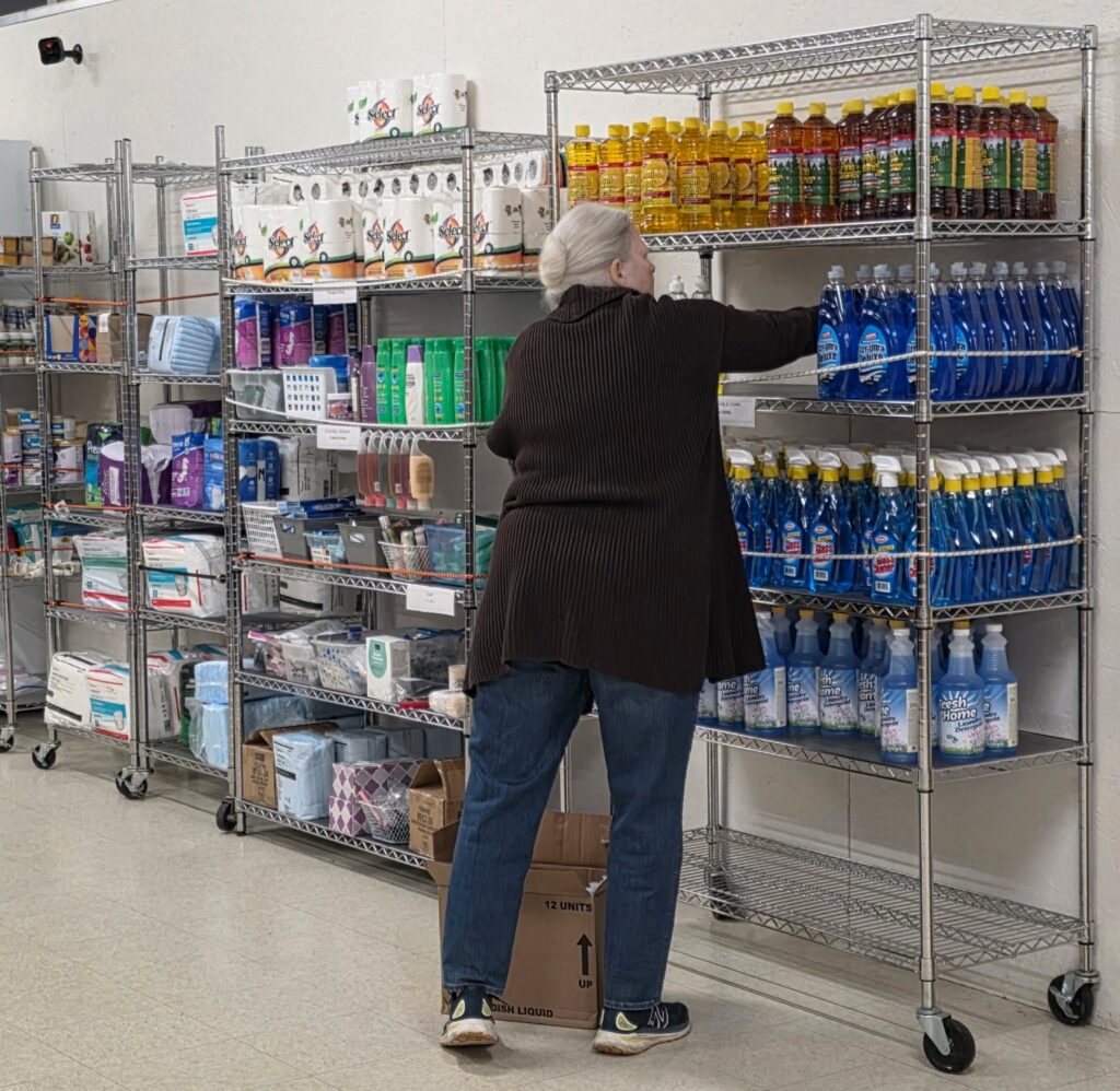Volunteer restocking shelves